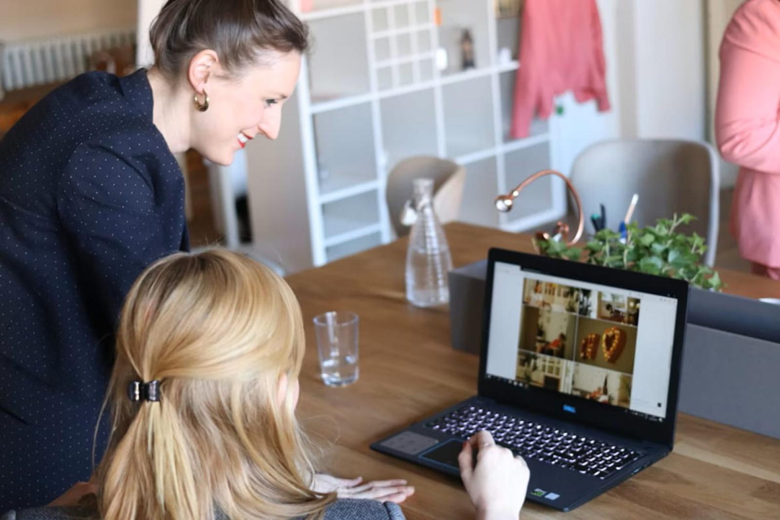 Two professionals looking at a laptop together. Photo by CoWomen on UnSplash